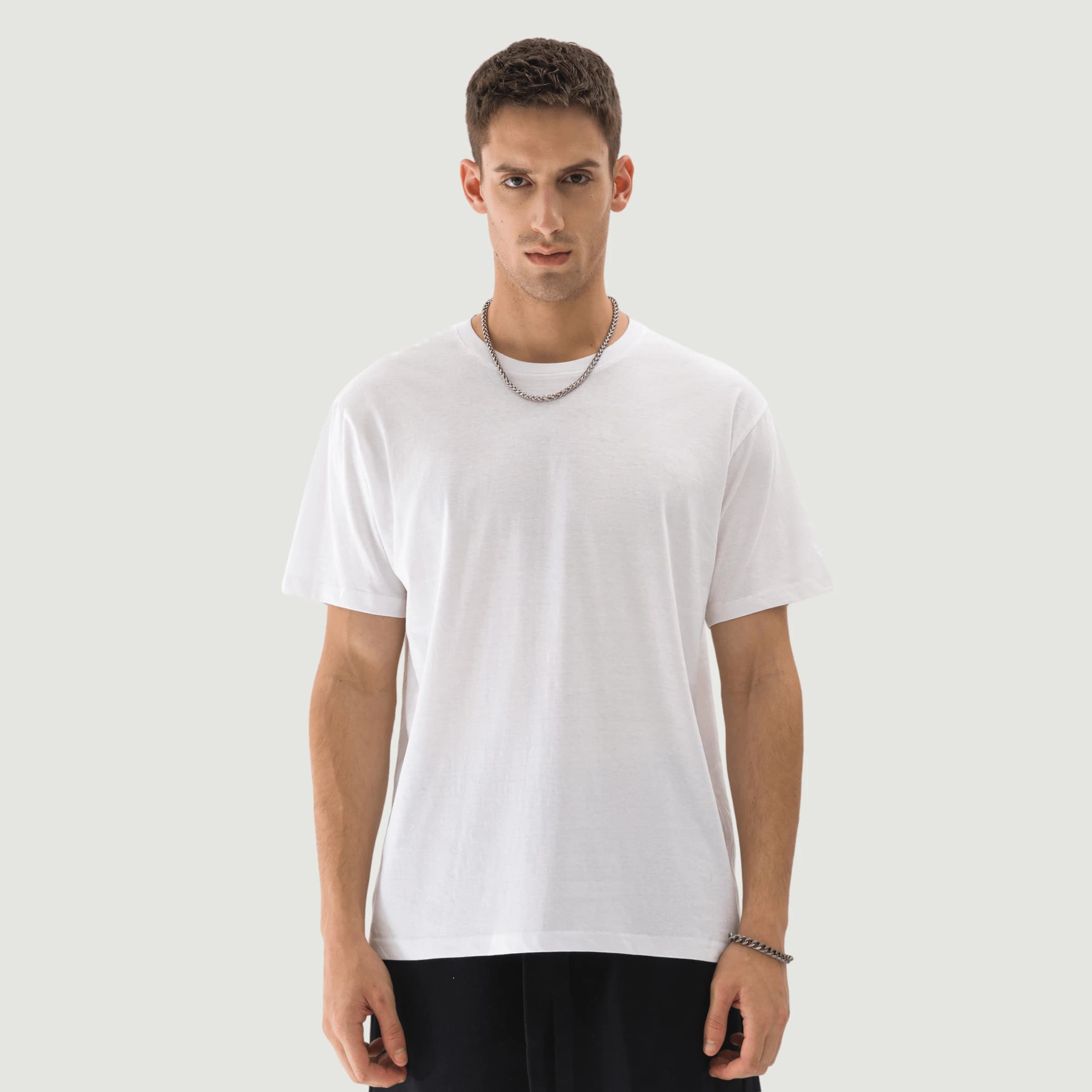 Thin 150GSM white tee on a model, fabric hanging limp and clinging to the torso